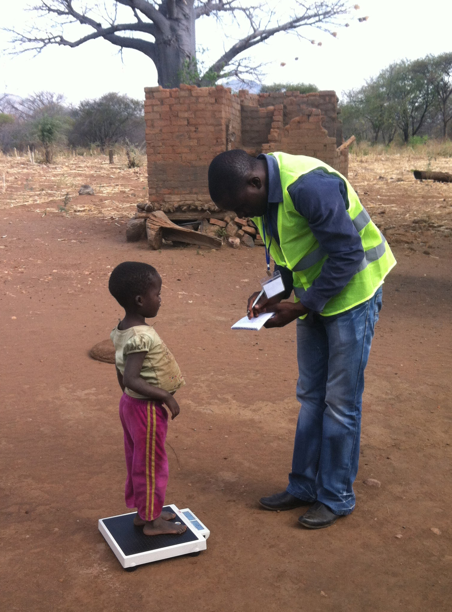 Man weighing child in Zimbabwe