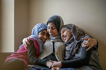 Muslim mother and daughters hugging