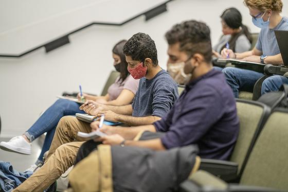 Masked college students in a classroom